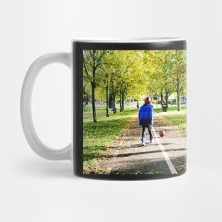 Boy playing football in autumn Mug